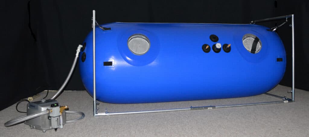A mild hyperbaric oxygen chamber with its compressor and support frame.