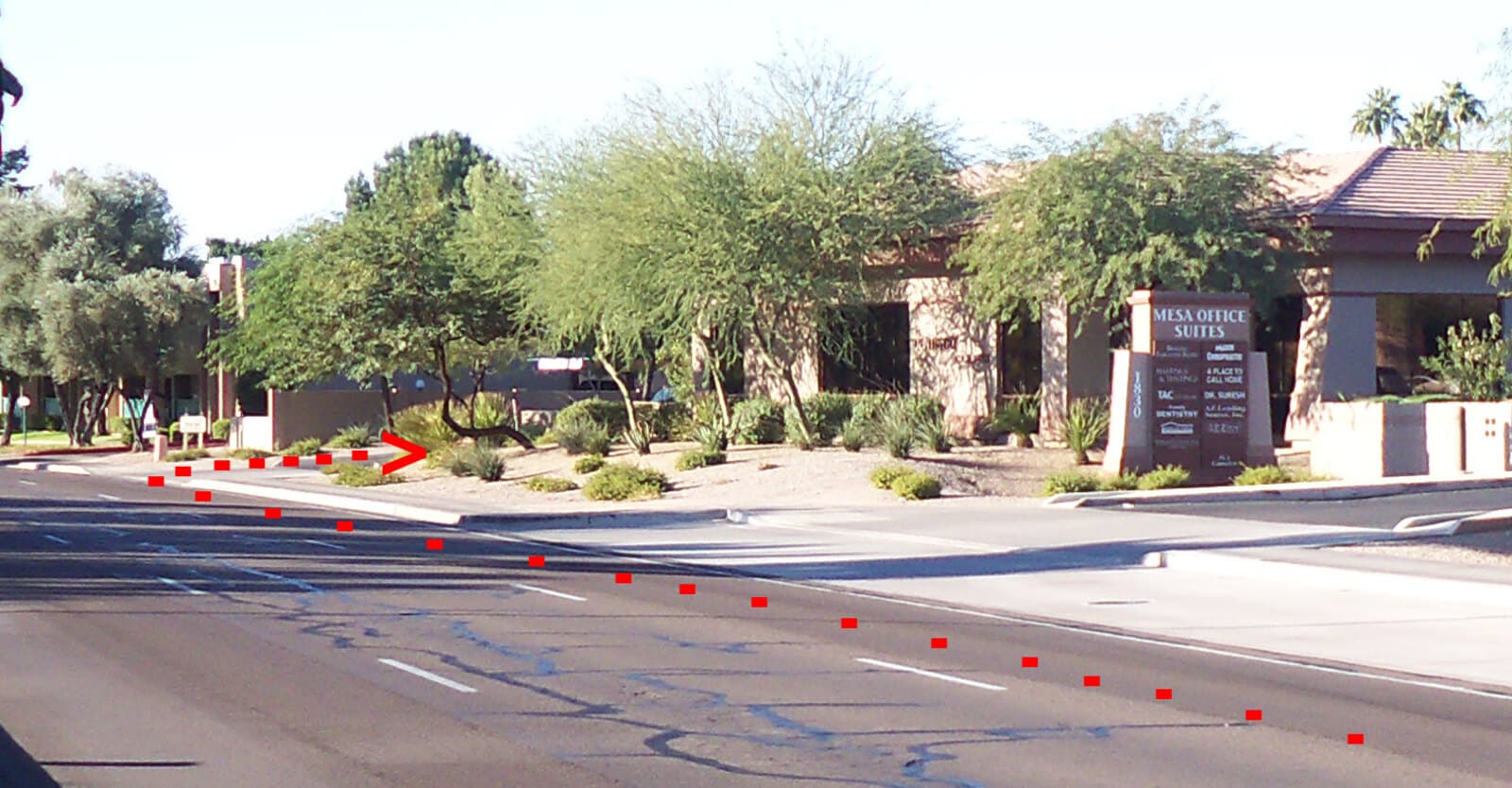 A red dotted arrow marking the turn from S Alma School Rd into the Mesa Office Suites parking lot.